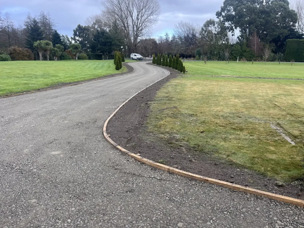 Driveway construction in progress with base course and timber edging