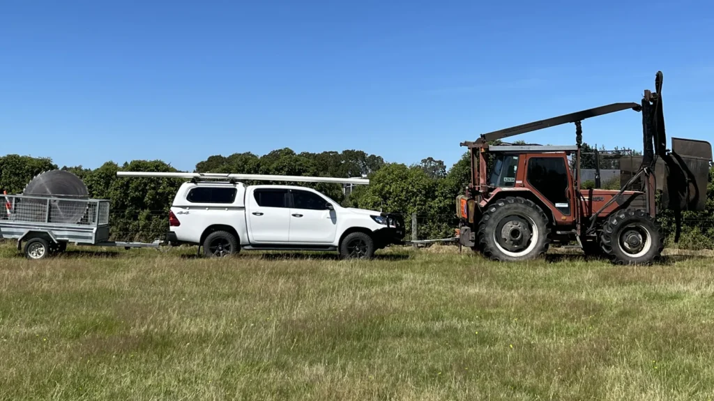 Tractor-mounted hedge trimmer saw and Waghorn Contracting ute on a Canterbury farm